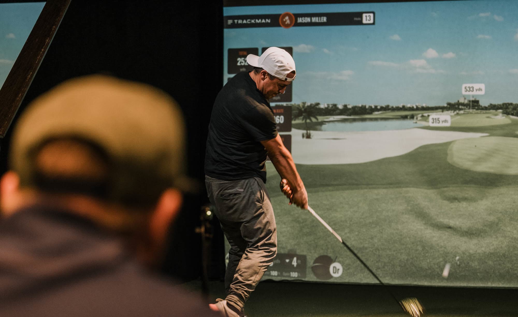 Golfer training in a Trackman simulator bay